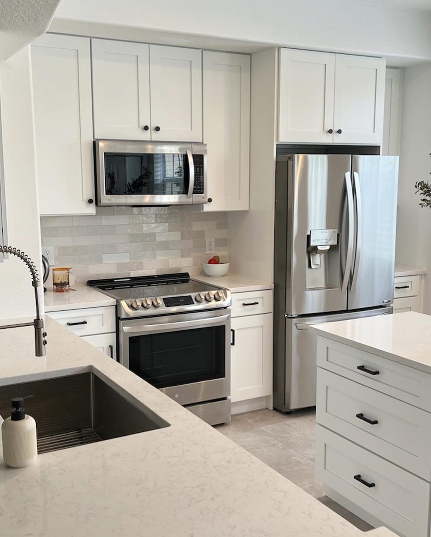 Clean white shaker kitchen with stainless steel appliances