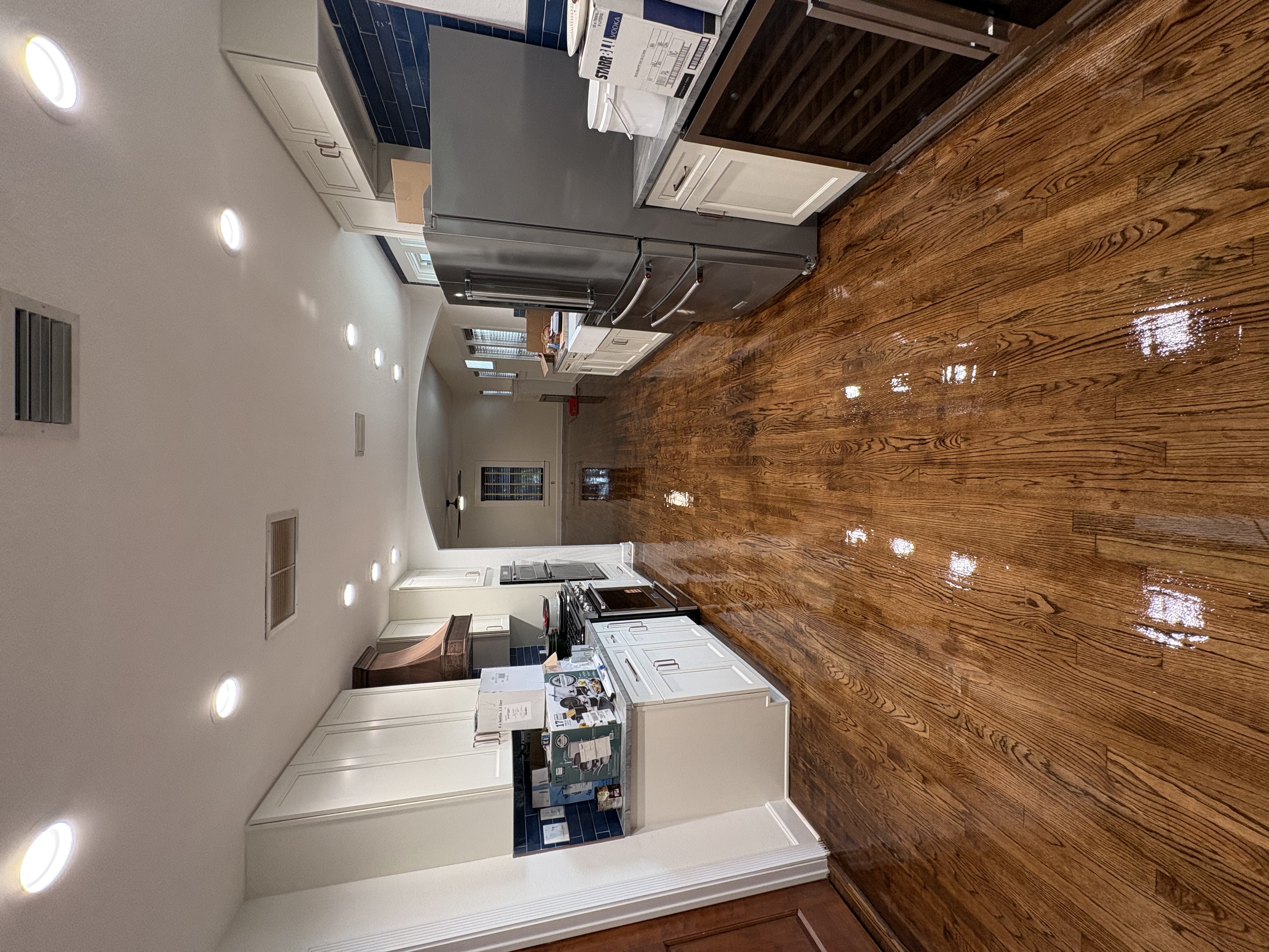 Spacious kitchen with white cabinets and hardwood flooring