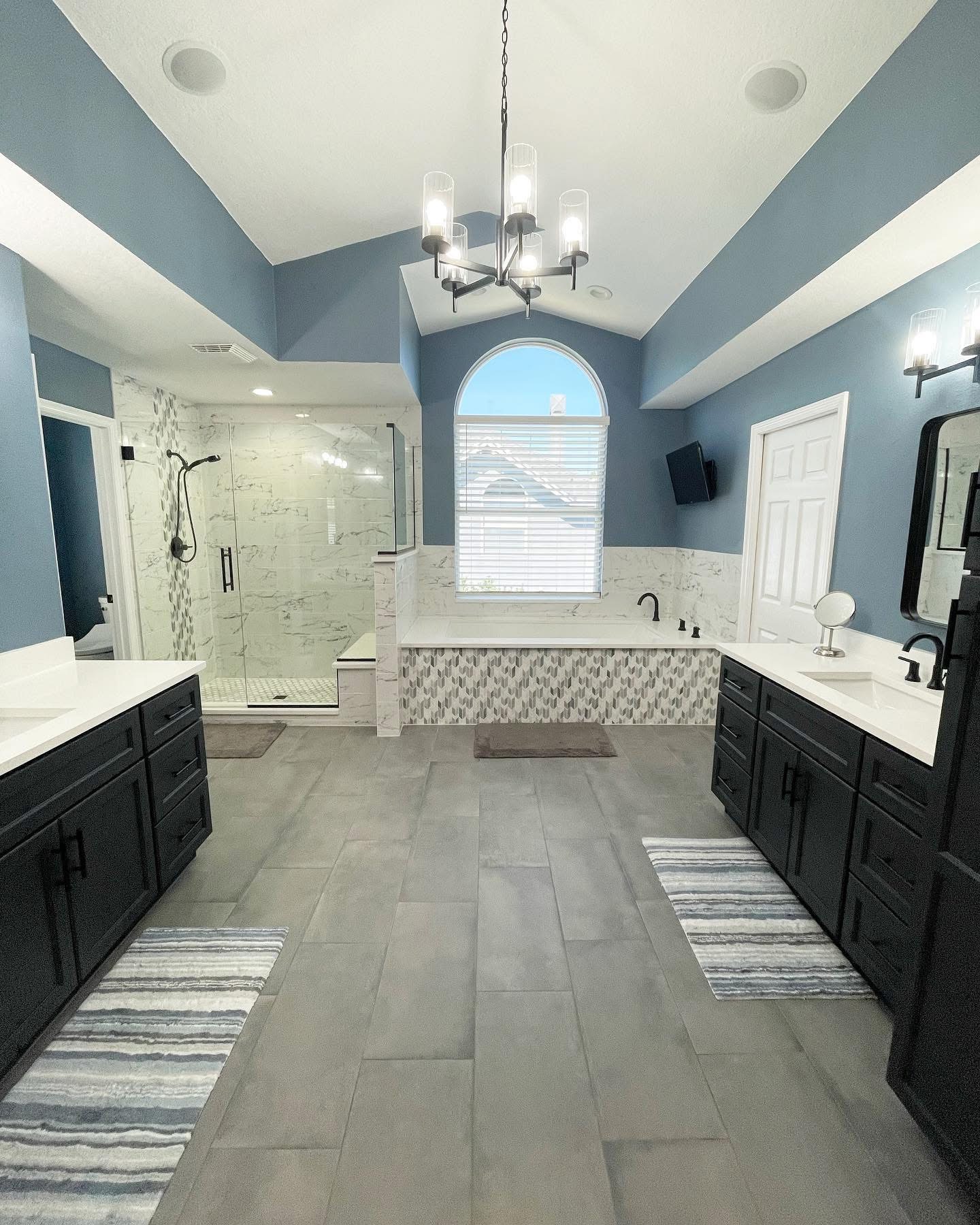Large master bathroom with vaulted ceiling, dual vanities, walk-in shower, and soaking tub