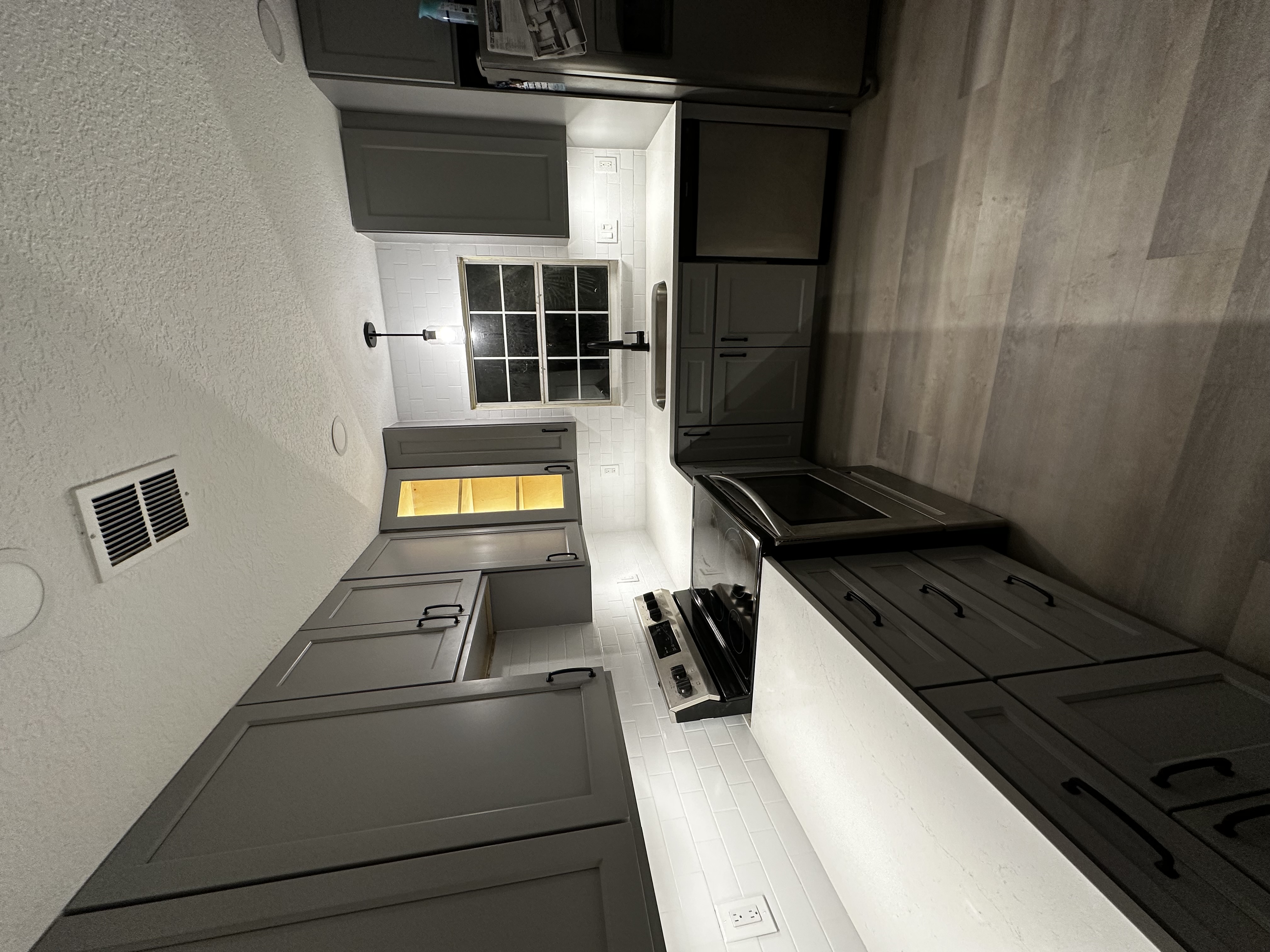 Gray shaker cabinet kitchen with white countertops and classic styling